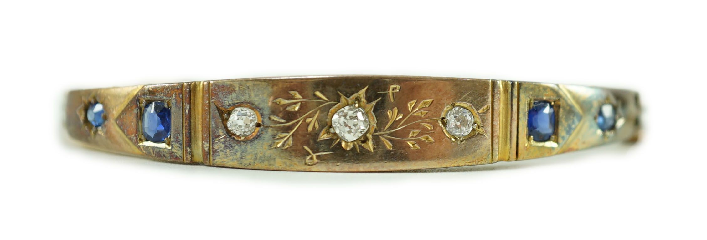 A late Victorian engraved gold, gypsy set three stone diamond and four stone sapphire set hinged bangle